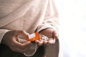 A person holding a packet of pills.