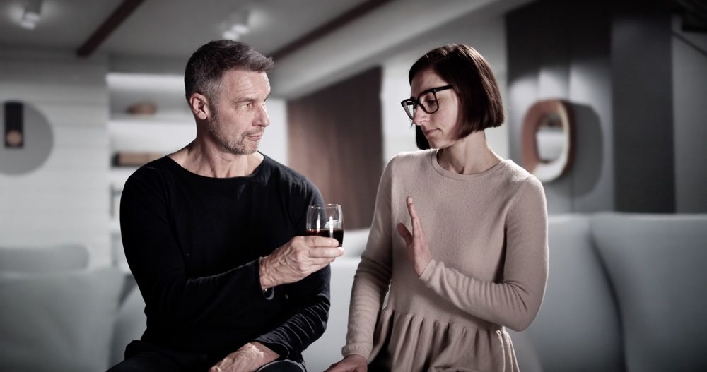 Woman wearing glasses declining alcohol to stay sober