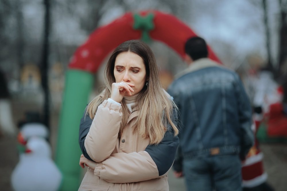 Sober woman feeling isolated during an outdoor holiday event