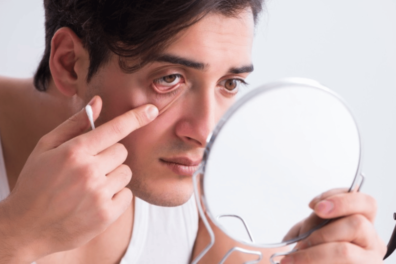 Man looking at the mirror looking if he has cocaine eyes