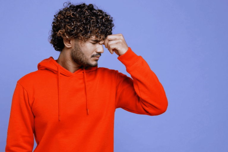 Male wearing a hoodie closing his eyes wondering what cocaine eyes look like