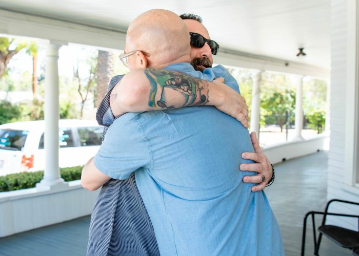 An image of two men hugging each other.